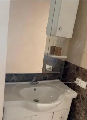a bathroom with a white sink and a white cabinet at Appartement al yakout 1 in Mansouria