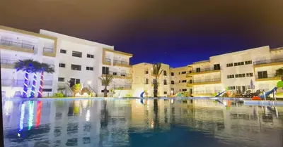 a large pool of water in front of buildings at Appartement al yakout 1 in Mansouria