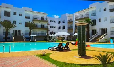 a resort with a swimming pool and a building at Appartement al yakout 1 in Mansouria