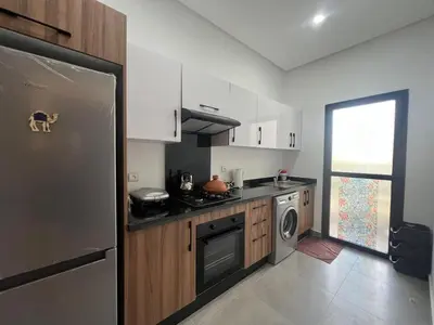 a kitchen with a refrigerator and a stove top oven at El Mansouria Mohammedia, Magic House T5 in Mansouria