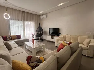 a living room with white couches and a tv at El Mansouria Mohammedia, Magic House T5 in Mansouria