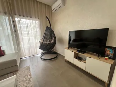 a living room with a large flat screen tv at El Mansouria Mohammedia, Magic House T5 in Mansouria