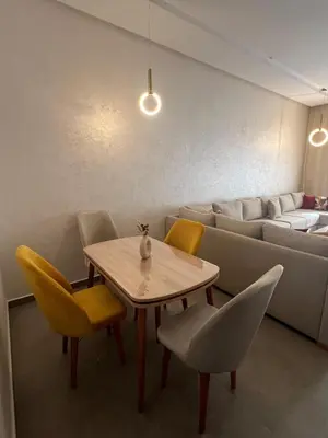 a room with a table and chairs and a couch at El Mansouria Mohammedia, Magic House T5 in Mansouria