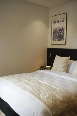 a bedroom with a large white bed with a picture on the wall at Luxury 1BR CFC with Pool, Balcony & City View in Casablanca