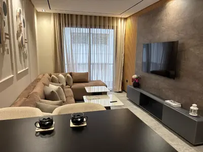 a living room with a couch and a tv at Bridge Collection - Mirage in Casablanca