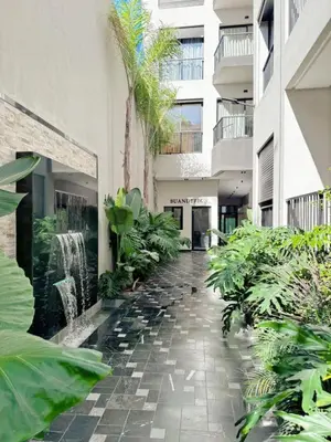 a courtyard of a building with palm trees and plants at anfa park residence beau living park in Casablanca