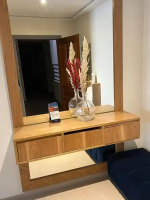 a dresser with a mirror and two vases with flowers on it at Charmant appartement in Casablanca center city in Casablanca