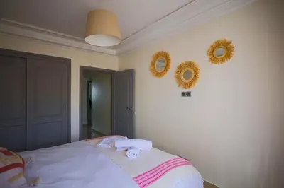 a bedroom with a bed and two mirrors on the wall at Charmant appartement in Casablanca center city in Casablanca
