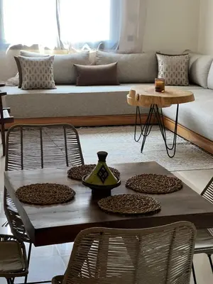 a table and chairs in a living room with a couch at Charmant appartement in Casablanca center city in Casablanca