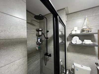 a shower with a glass door in a bathroom at Cosy Appart au Parc Mohammédia in Mohammedia