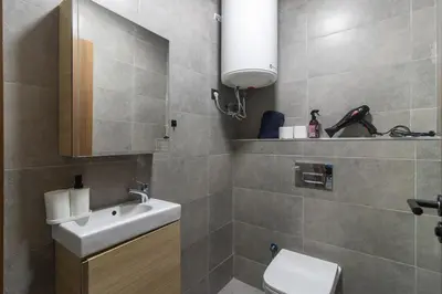 a bathroom with a white sink and a toilet at Piscine Chauffée Salle de Sport Balcon Panoramique in Mohammedia