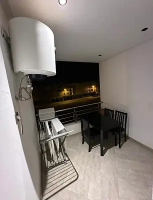 a dining room with a table and a view of the city at Cozy appartement avec piscine in Bouznika