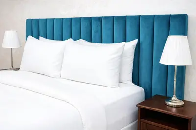 a bed with a blue headboard and white pillows at Studio Paisible aux Hopitaux Wifi & Parking in Casablanca