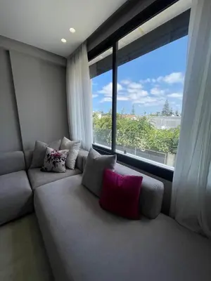 a couch in a room with a large window at Cozy studio for rent Casablanca in Casablanca