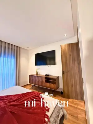 a bedroom with a bed and a flat screen tv at Happy - 2 BR - Downtown Casablanca in Casablanca