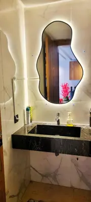 a bathroom with a black sink and a mirror at Les-iris-Appartement-moderne-chambre-salon-au-cœur-de-Casablanca in Casablanca