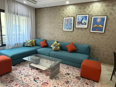 a living room with a blue couch and orange chairs at Urban Square in Casablanca
