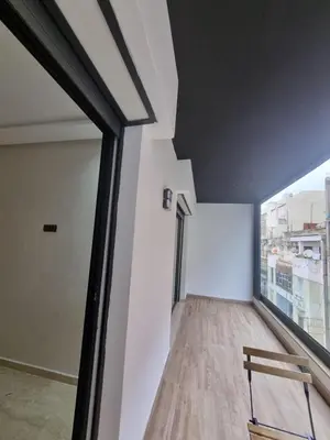 a room with a large window and a wooden floor at Maarif Cosy Studios in Casablanca