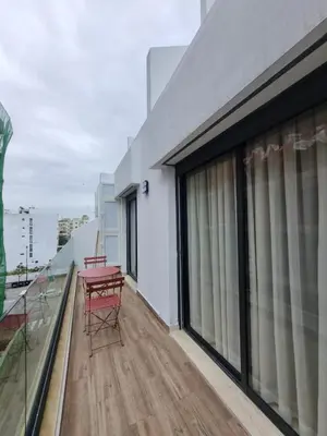 a balcony with two red chairs on top of a building at Maarif Cosy Studios in Casablanca