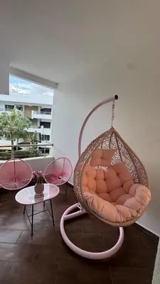 a hanging chair in a room with a table at Charming 3 bedroom with pool in the building in Casablanca