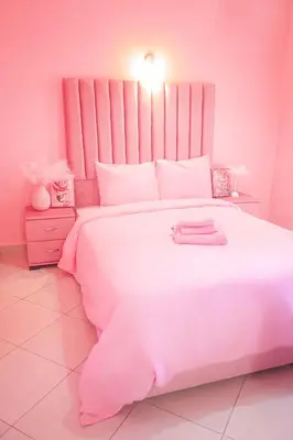 a pink bedroom with a large white bed at Charming 3 bedroom with pool in the building in Casablanca