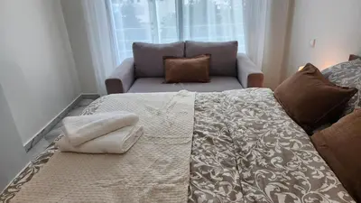 a bedroom with a bed with a couch and a window at Appartement modern tramway in Casablanca