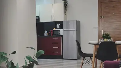 a kitchen with a refrigerator and a table with chairs at Appartement modern tramway in Casablanca