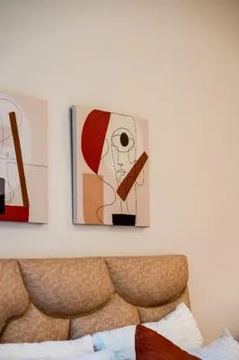 a painting of a woman with a cigar on a wall at L'Amber 1 chambre - 5 min de l'Aéroport- Piscine in Nouaseur