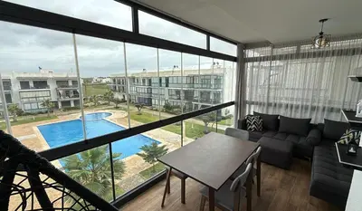 a living room with a view of a pool at Appartement Résidence Tamaris Park in Tamaris
