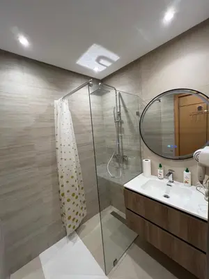 a bathroom with a shower and a sink and a mirror at Central T1 cozy and chic in Rabat