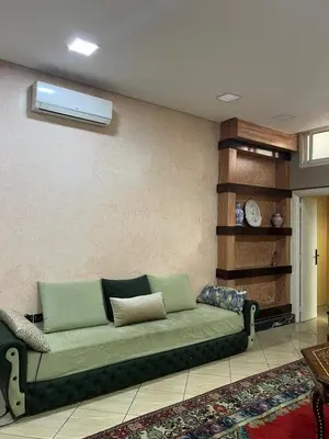 a living room with a green couch in a room at Cozy Apartment Rabat in Rabat