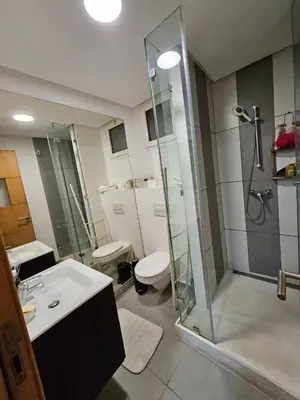 a bathroom with a shower and a sink and a toilet at Appartement lumineux avec parking privé in Temara