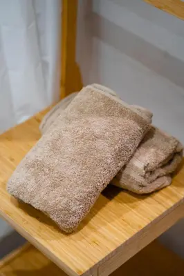 a pile of towels sitting on a wooden table at Le Rubis - Appartement pour 3 personnes - Avec Piscine - Proche aeroport Mohammed 5 in Nouaseur