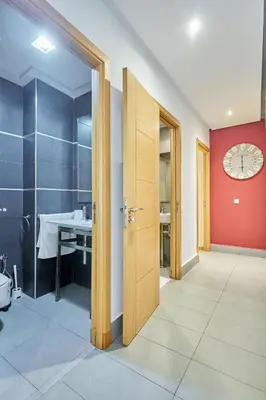 a bathroom with a red wall and a clock on the wall at Chic 3BR in Racine by Bd Massira in Casablanca