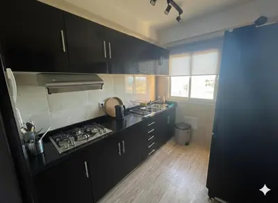 a kitchen with black cabinets and a stove top oven at Appartement vue sur mer - Chill ocean view in Rabat