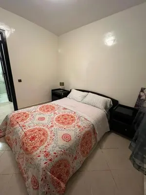 a bedroom with a bed with a red and white blanket at 2 Bedrooms 3 beds and a living room in Dar Bouazza in Dar Ben Abdallah Ben Dehbi