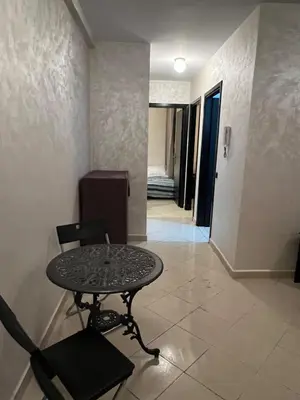 a table and chair in a room with a hallway at 2 Bedrooms 3 beds and a living room in Dar Bouazza in Dar Ben Abdallah Ben Dehbi