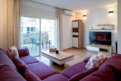 a living room with a purple couch and a tv at Appartement luxueux &chaleureux au cœur de Rabat in Rabat