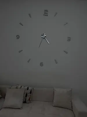 a clock on a white wall above a couch at Havre de paix in Rabat