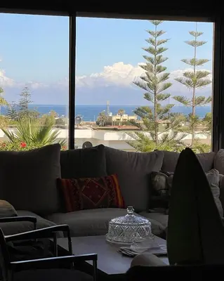 a living room with a couch and a view of the ocean at Harhoura Sea view apartment with green spaces and a pool in El Harhoura