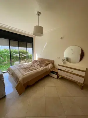 a bedroom with a large bed and a mirror at Harhoura Sea view apartment with green spaces and a pool in El Harhoura