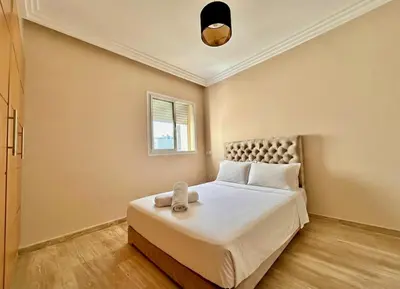 a bedroom with a bed and a window at 2BR Sea View Apartment - Balcony I Parking in Rabat