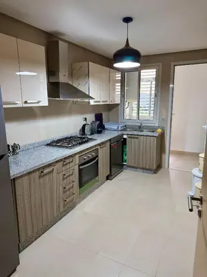 a kitchen with white cabinets and a stove top oven at Prestigia Golf City Bouskoura in Bouskoura