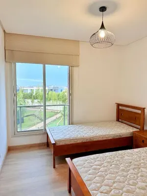 a bedroom with two beds and a large window at Prestigia Golf City Bouskoura in Bouskoura