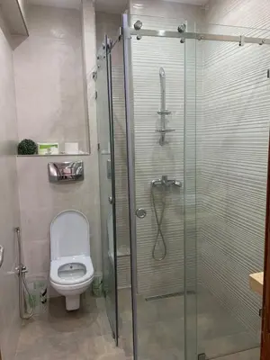 a bathroom with a toilet and a glass shower at Cozy apt in Bourgogne - Ain Diab Coast in Casablanca
