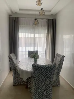 a dining room table with chairs and a window at Cozy apt in Bourgogne - Ain Diab Coast in Casablanca