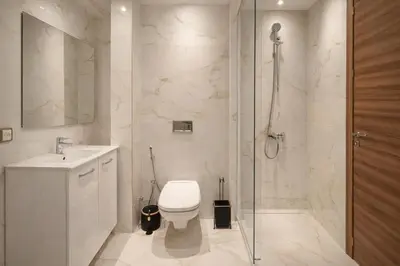 a bathroom with a toilet and a sink and a shower at Modern Cozy Apartment in Prime Location in Nouaceur