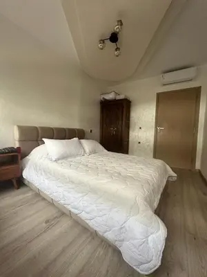 a large white bed in a bedroom with a ceiling at Chez Abir in Rabat
