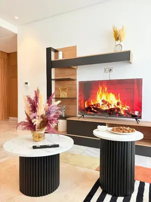 a fireplace in a living room with two tables in front of it at Havre de paix chic avec terrasse Maarif Palmier Casablanca in Maarif