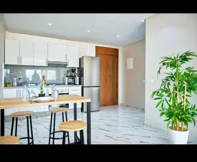 a kitchen with a table and some plants in it at Magnifique studio disponible sur roche noire in Casablanca
